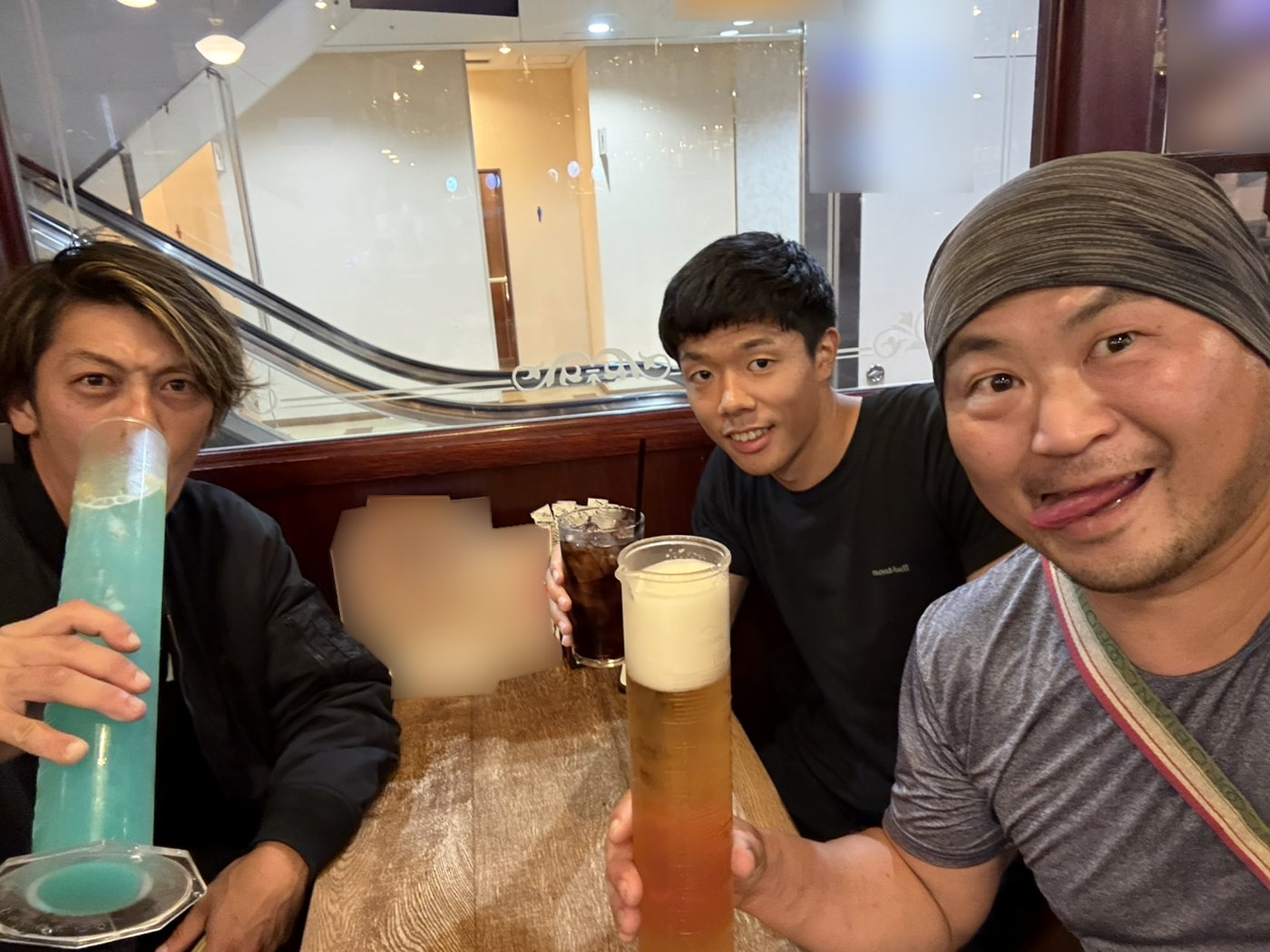 仕事のあと、店で大きなグラスの飲み物を手に笑うスタッフ3人